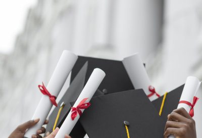 close-up-hands-holding-diplomas-caps